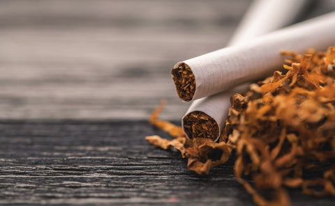 Cigarettes and tobacco leaves on a wooden surface