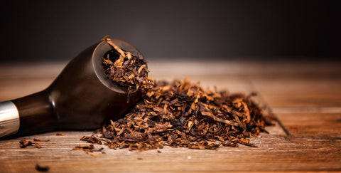 Tobacco leaves on a wooden scoop with a dark background